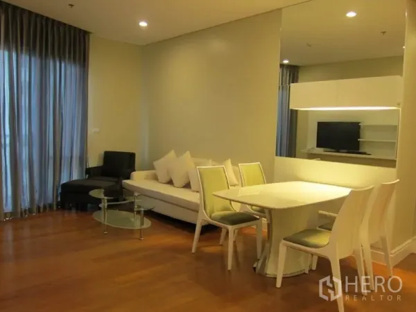 คอนโด ให้เช่าในKhlong Toei, Bangkok - ห้องนั่งเล่นสว่างโปร่ง ผ้าม่านสูงจรดเพดาน ชุดโซฟา และโต๊ะกระจก ในคอนโดสไตล์โมเดิร์น