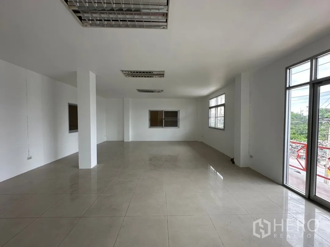 Factory for rent in Bang Sao Thong, Samut Prakan - Open‑plan office level with large windows and balcony outlook over the project road.
