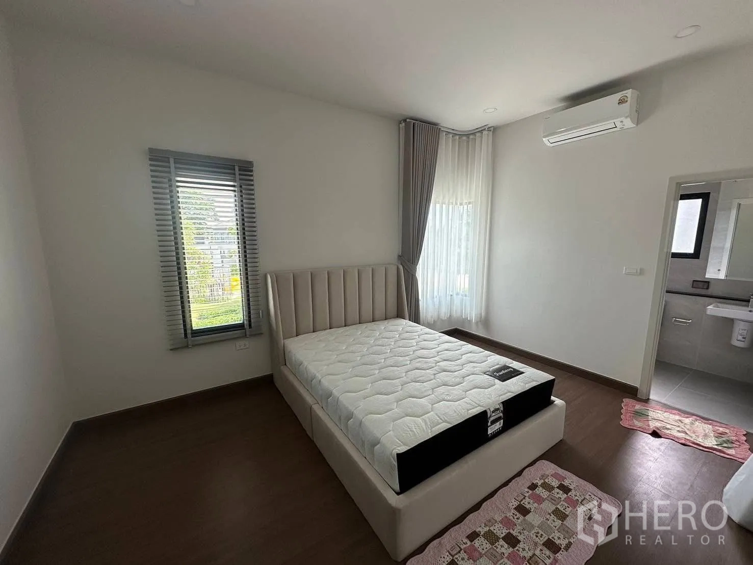 บ้านเดี่ยว for rent in Bang Phli, Samut Prakan - ห้องนอนสว่าง พร้อมเตียง พื้นไม้ เครื่องปรับอากาศ หน้าต่างมุม และห้องน้ำในตัว ในบ้านเดี่ยวบางพลี สมุทรปราการ