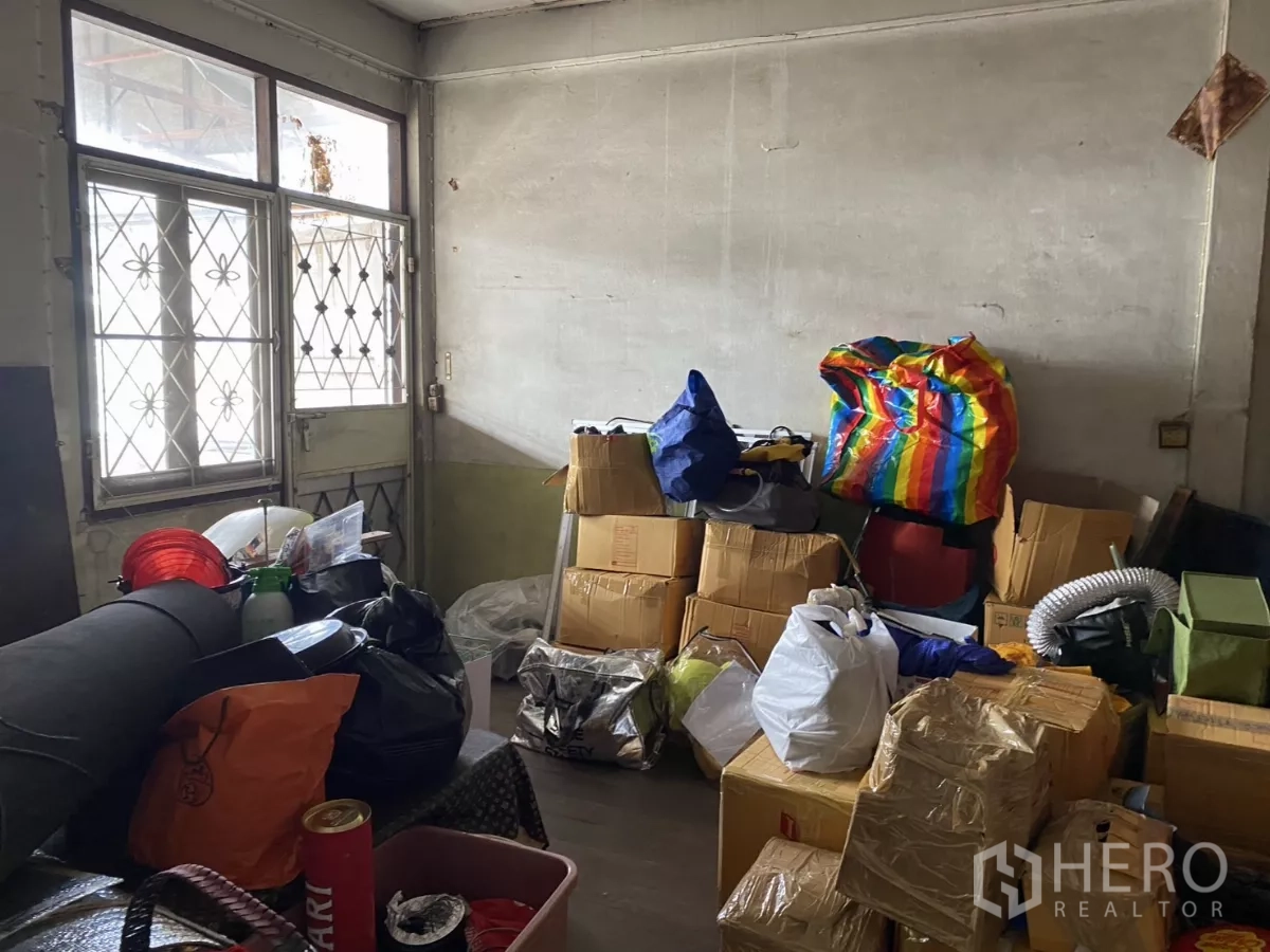 店屋 出租在Khlong Toei, Bangkok - 储物房带防盗窗，堆放多个纸箱与袋子。