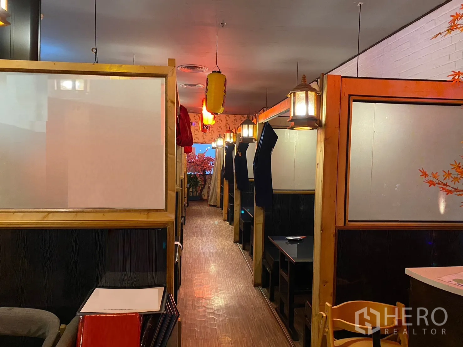 零售空间 出租在Watthana, Bangkok - 长廊两侧为餐厅卡座，木质装饰与灯笼点缀