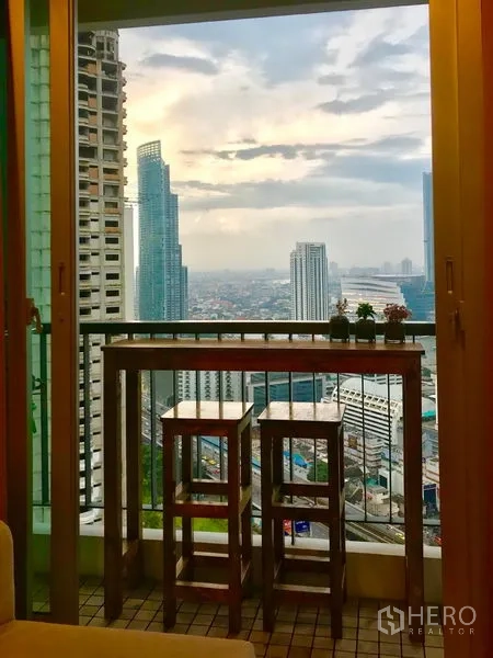 公寓 出租在Sathon, Bangkok - 阳台配置高吧桌与凳子，俯瞰曼谷高楼景致