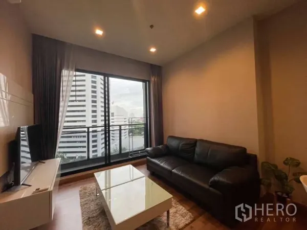 公寓 出售在Huai Khwang, Bangkok - 客厅连接阳台，通过大推拉窗可见城市景观。