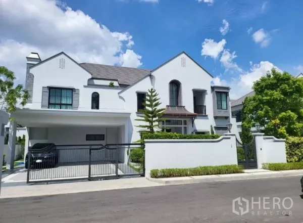 บ้าน ให้เช่าในSaphan Sung, Bangkok - ด้านหน้าบ้านเดี่ยวสีขาวพร้อมรั้วและที่จอดรถ