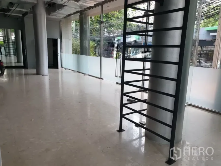 Office Space for rent in Khlong Toei, Bangkok - Open-plan office interior with floor-to-ceiling glass windows, polished floors, and exposed ceiling in the Sukhumvit area.