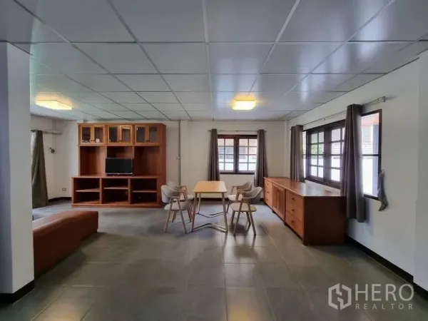 独立式住宅 出租在Nonthaburi - 宽敞客餐厅，落地窗、瓷砖地面与木质收纳柜。