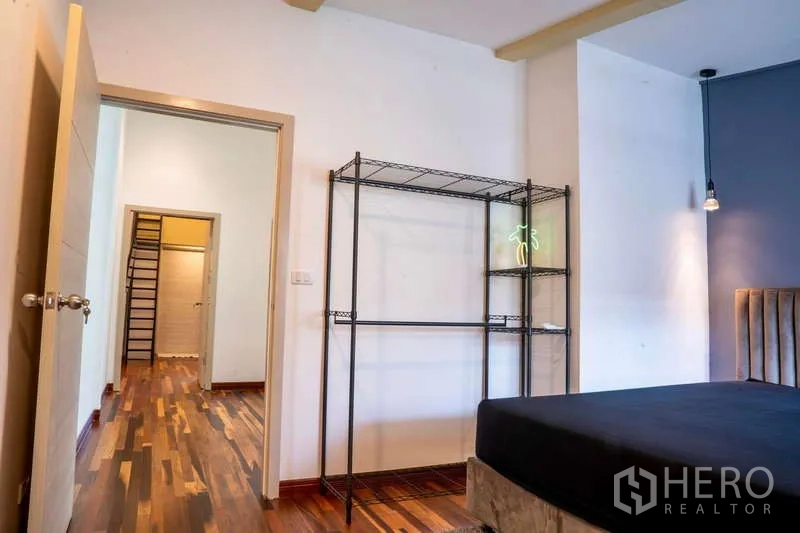 联排别墅 出租在Khlong Toei, Bangkok - 卧室朝走廊视角，木地板与开放收纳架