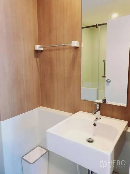 Condominium for rent in Sathon, Bangkok - Bright living room with sofa, TV stand and balcony access through sliding doors.