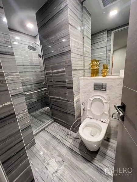คอนโด ให้เช่าในWatthana, Bangkok - ห้องน้ำอีกห้องพร้อมโถสุขภัณฑ์ เรนชาวเวอร์ และผนังหินอ่อนโทนเทา