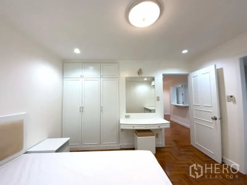 คอนโด ให้เช่าในWatthana, Bangkok - ห้องนอนพร้อมตู้เสื้อผ้าบิลท์อินสีขาว โต๊ะเครื่องแป้ง และพื้นไม้
