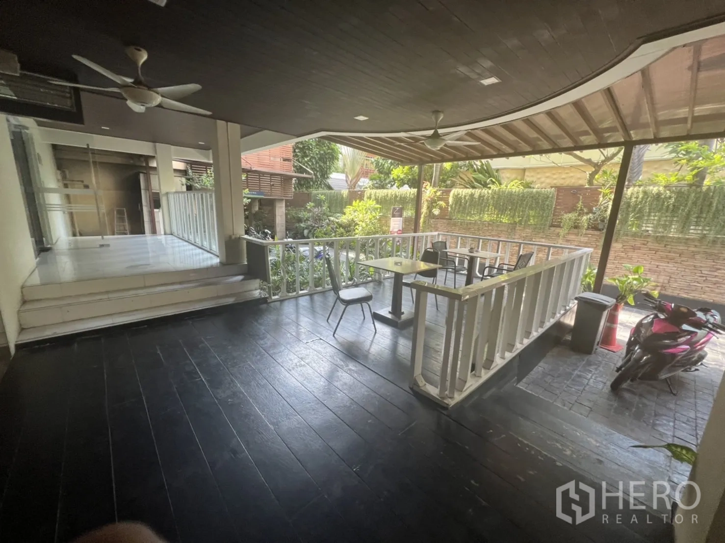 พื้นที่ขายปลีก ให้เช่าในKhlong Toei, Bangkok - ระเบียงครึ่งเปิด มีพัดลมเพดาน ราวกั้น โต๊ะเล็ก และต้นไม้ริมทางเข้า