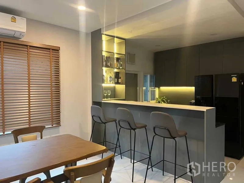 บ้าน ให้เช่าหรือขายในLat Krabang, Bangkok - มุมทานข้าวโต๊ะไม้ติดเคาน์เตอร์บาร์ พร้อมเก้าอี้สูงและชั้นโชว์ไฟในตัว