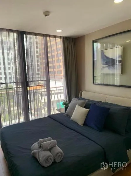 Condominium for rent or sale in Pathum Wan, Bangkok - Corner bedroom with floor-to-ceiling windows and skyline views near BTS Phloen Chit.