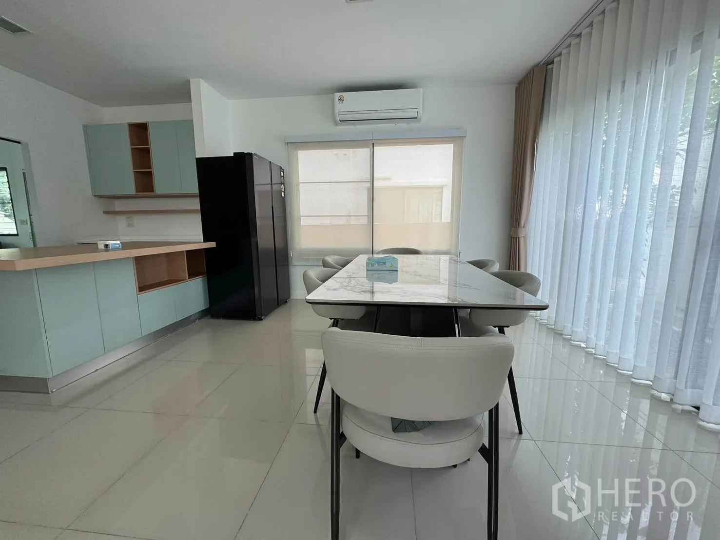 บ้านเดี่ยว for rent in Prawet, Bangkok - พื้นที่รับประทานอาหารแบบเปิดโล่ง ผ้าม่านโปร่ง ตู้ครัวบิวท์อินโทนพาสเทล และตู้เย็นสีดำ