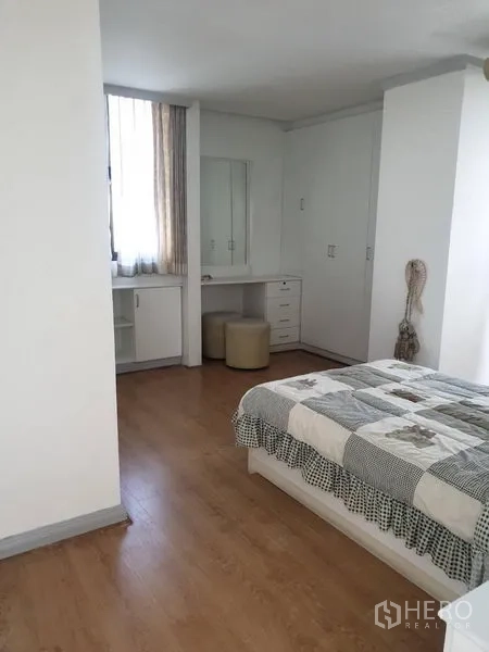 Condominium for rent in Watthana, Bangkok - Master bedroom with dressing table, wardrobes, and natural light.