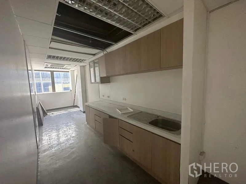 Office Space for rent in Khlong Toei, Bangkok - Pantry with built-in cabinets, sink and countertop, ready for staff kitchen use.