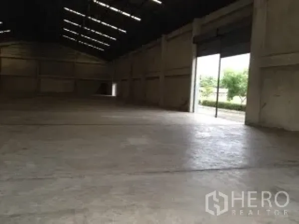 Warehouse for rent in Nakhon Pathom - Open-plan warehouse bay with large roller shutter door and natural light onto the loading apron.