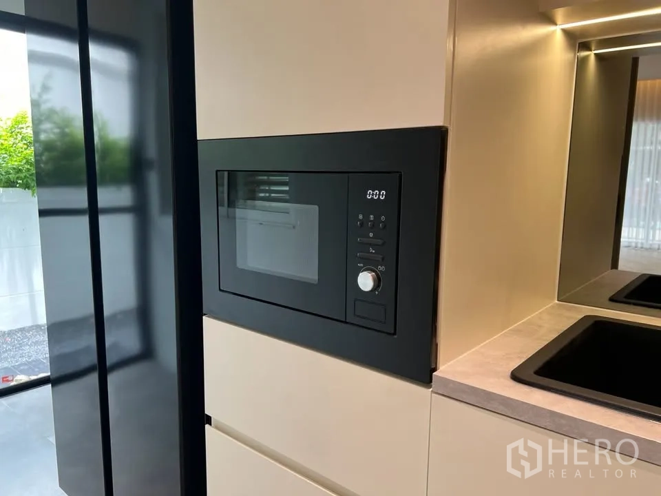 Townhouse for rent in Prawet, Bangkok - Built-in microwave integrated into kitchen cabinetry.