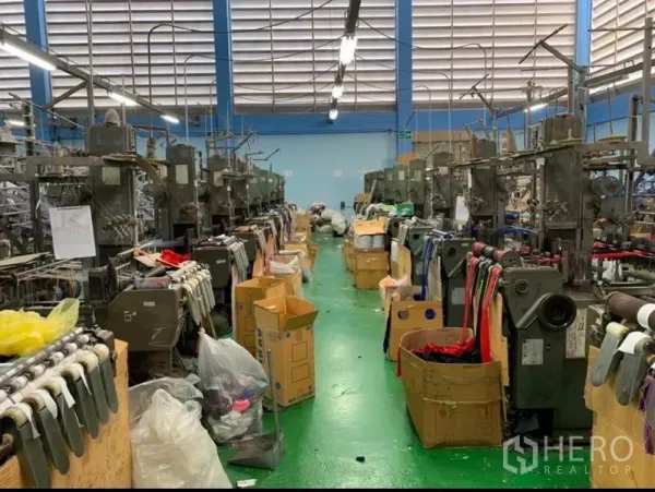 คลังสินค้า ขายในMueang Samut Sakhon, Samut Sakhon - ทางเดินระหว่างแถวเครื่องจักรบนพื้นโรงงานสีเขียวและไฟสว่าง