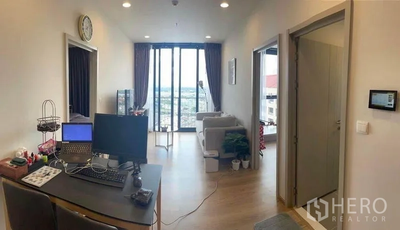 คอนโด ให้เช่าในKhlong Toei, Bangkok - ห้องนั่งเล่นโอเพ่นแปลน มีมุมทำงานและโซฟา เชื่อมสู่ระเบียงวิวสกายไลน์