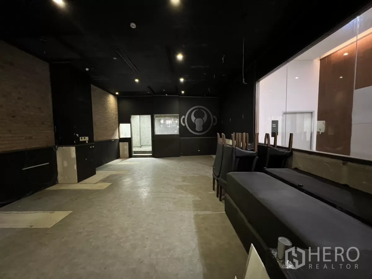 พื้นที่ขายปลีก ให้เช่า - พื้นที่รับประทานอาหารกว้าง เพดานสีดำ ผนังอิฐโชว์ และหน้าต่างภายในสู่ห้องครัว