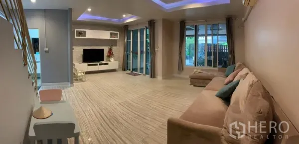 Detached House for sale in Din Daeng, Bangkok - Open-plan lounge with large windows, sliding glass doors and neutral tile flooring.