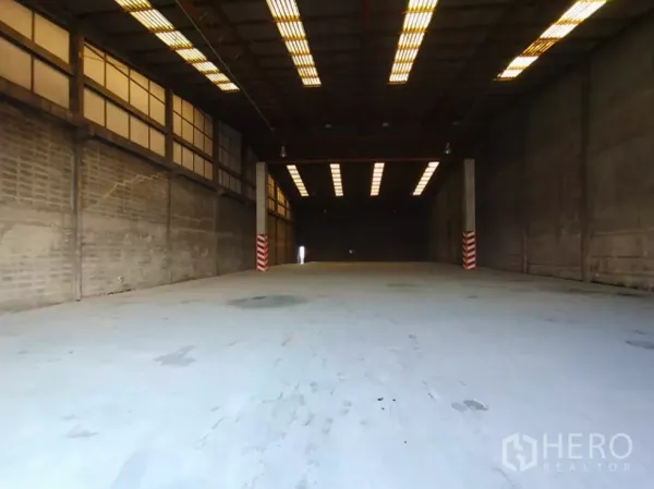 工厂 出租在Phra Pradaeng, Samut Prakan - 宽敞厂房内景，挑高空间、条形照明，重载混凝土地面适合叉车作业。