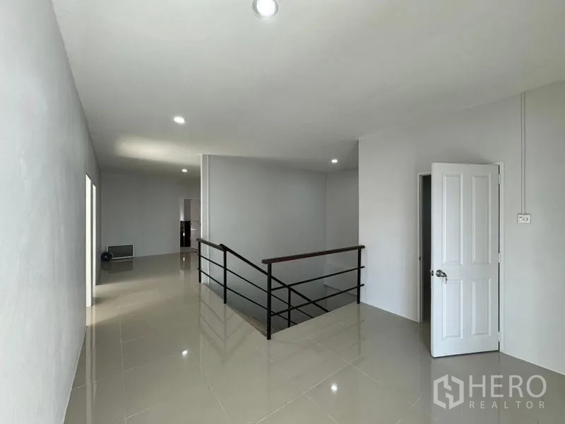 Warehouse for rent or sale in Chon Buri - Bright stair landing and hallway with doors leading to multiple rooms.