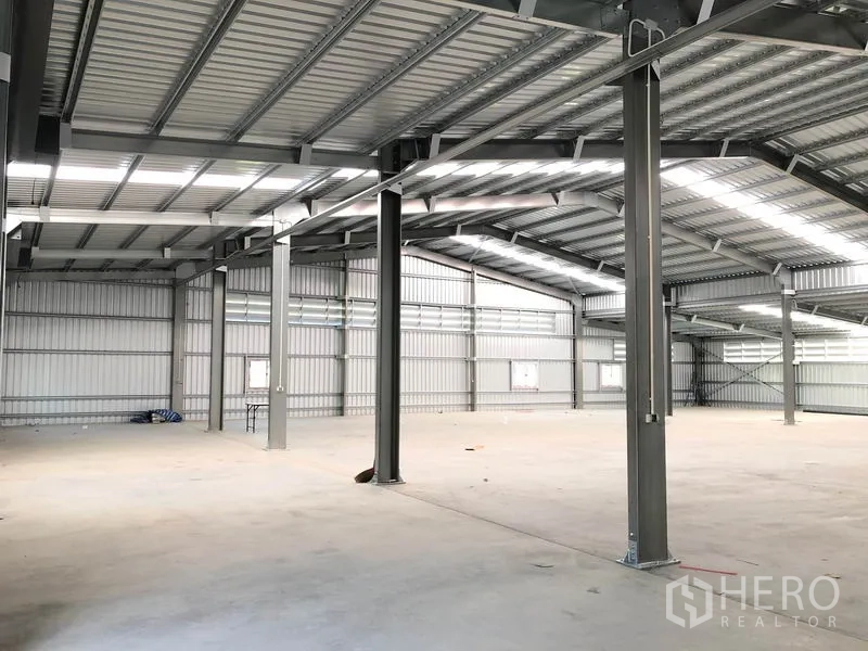 Warehouse for rent in Pak Kret, Nonthaburi - Clear-span warehouse interior with steel columns, high roof and smooth concrete floor.