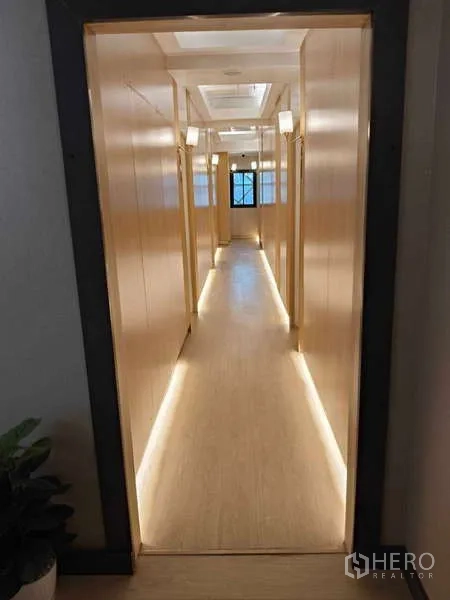 零售空间 出租在Khlong Toei, Bangkok - 长走廊，木质墙面与暖色灯带通向各房间。
