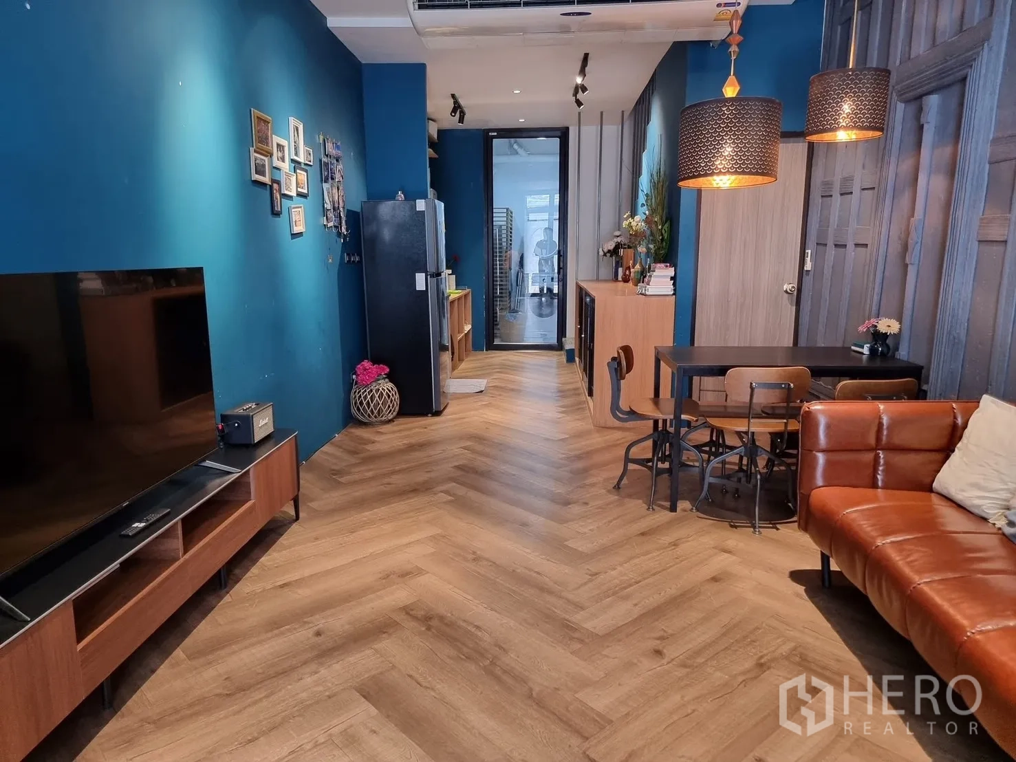 ทาวน์เฮาส์ for rent in Watthana, Bangkok - พื้นไม้ลายก้างปลา มุมทีวี โต๊ะทานข้าว โซฟาหนัง และตู้เย็นในพื้นที่นั่งเล่น