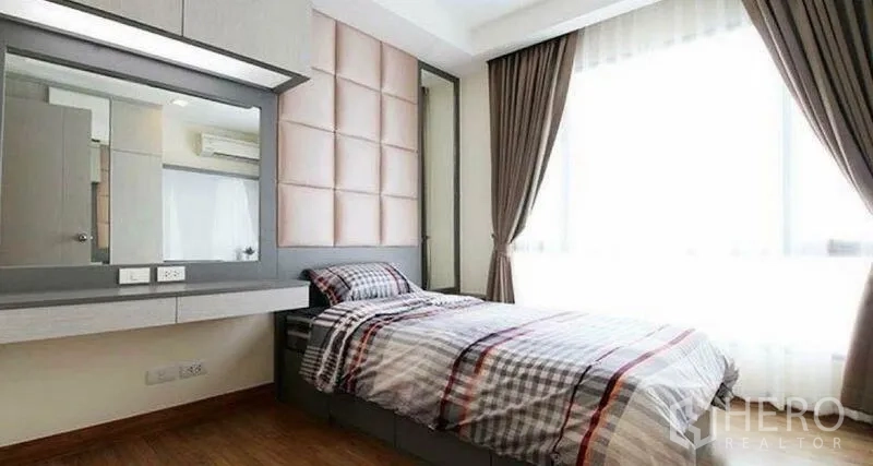 Condominium for rent in Huai Khwang, Bangkok - Sunlit single bedroom with large window, drapes and built-in storage.