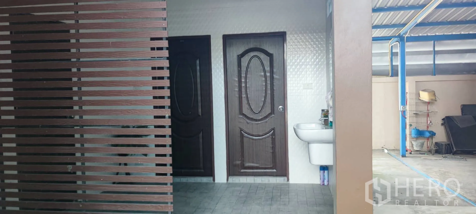 Warehouse for sale in Thung Khru, Bangkok - Exterior restrooms with two doors and a wall-mounted sink.
