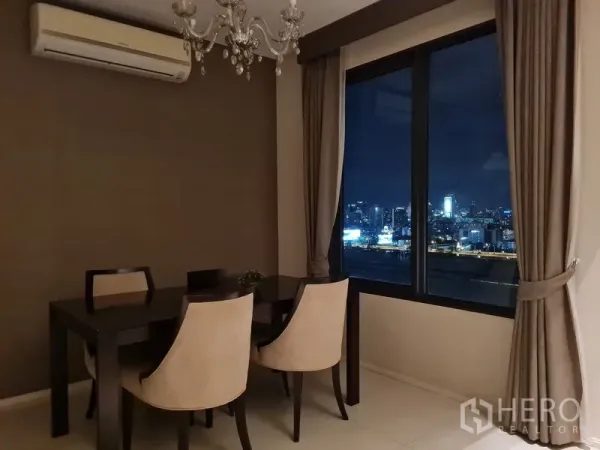คอนโด ขายในRatchathewi, Bangkok - มุมรับประทานอาหารพร้อมโคมแชนเดอเลียร์และหน้าต่างชมวิวกรุงเทพฯ ยามค่ำคืน