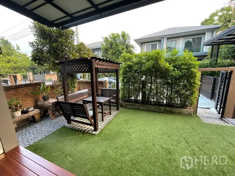 Detached House for rent - Front garden with a wooden pergola, seating set and green lawn.