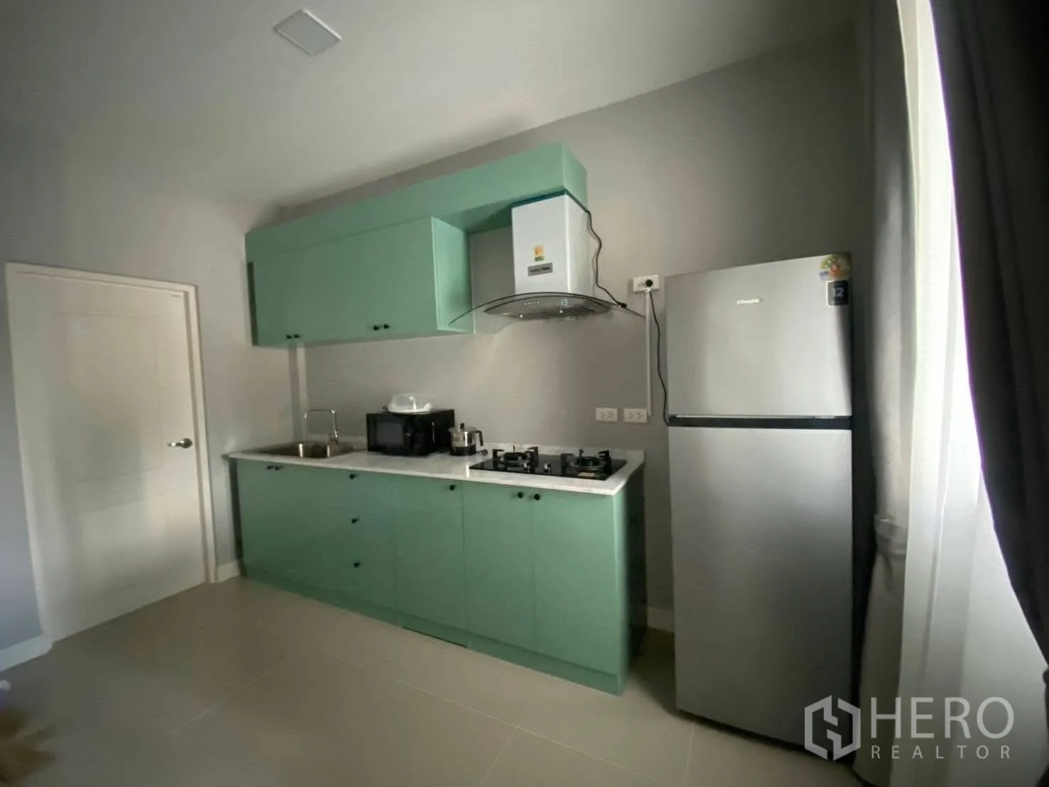 Detached House for rent in Bang Phli, Samut Prakan - Modern kitchen with mint-green cabinets, gas hob, hood and stainless refrigerator.