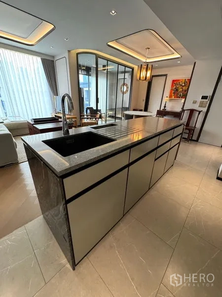 Condominium for rent in Watthana, Bangkok - Modern kitchen island with under-sink storage and stone worktop.