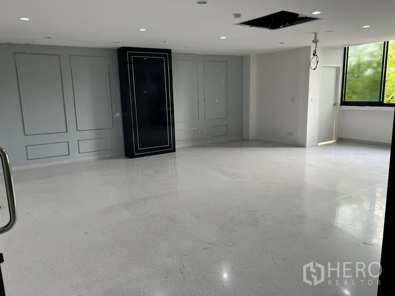 Office Space for rent in Mueang Samut Prakan, Samut Prakan - Bright open‑plan office with a large window and paneled feature wall.