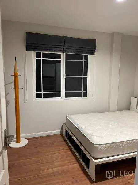 Detached House for rent in Bang Kapi, Bangkok - Guest bedroom with white bedframe, roman blind window and wood floors.