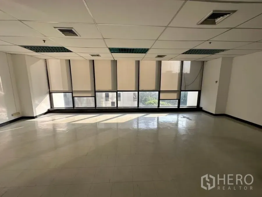 Office Space for rent in Ratchathewi, Bangkok - Bright empty office with full-width windows, roller blinds, tiled floor and drop ceiling near BTS Phaya Thai.