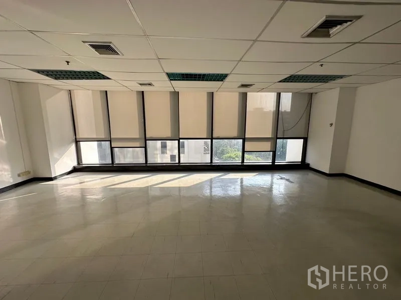 Office Space for rent in Ratchathewi, Bangkok - Bright empty office with full-width windows, roller blinds, tiled floor and drop ceiling near BTS Phaya Thai.
