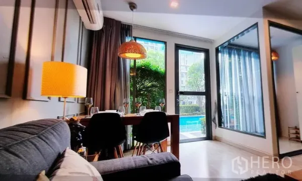 Condominium for rent in Phra Khanong, Bangkok - Dining corner opening to garden and swimming pool through glass door.