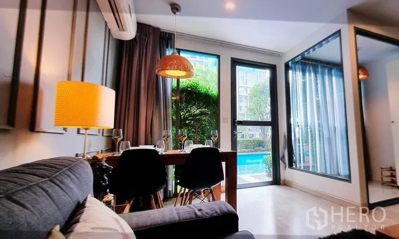 Condominium for rent in Phra Khanong, Bangkok - Dining corner opening to garden and swimming pool through glass door.