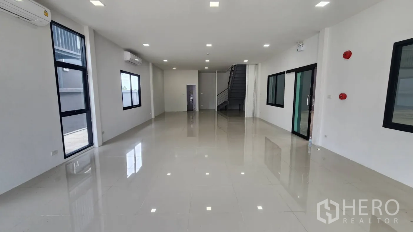 Factory for rent in Bang Bo, Samut Prakan - Bright ground-floor office with large windows, air-conditioning and stairs to the mezzanine.