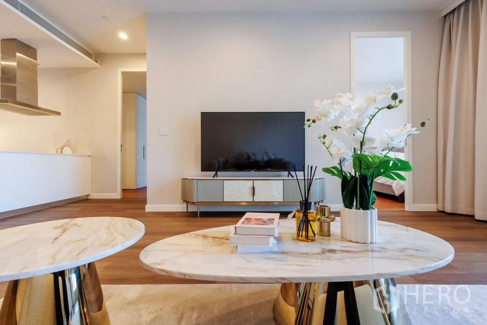 Condominium for rent or sale in Pathum Wan, Bangkok - Living room view with marble coffee tables and TV console.