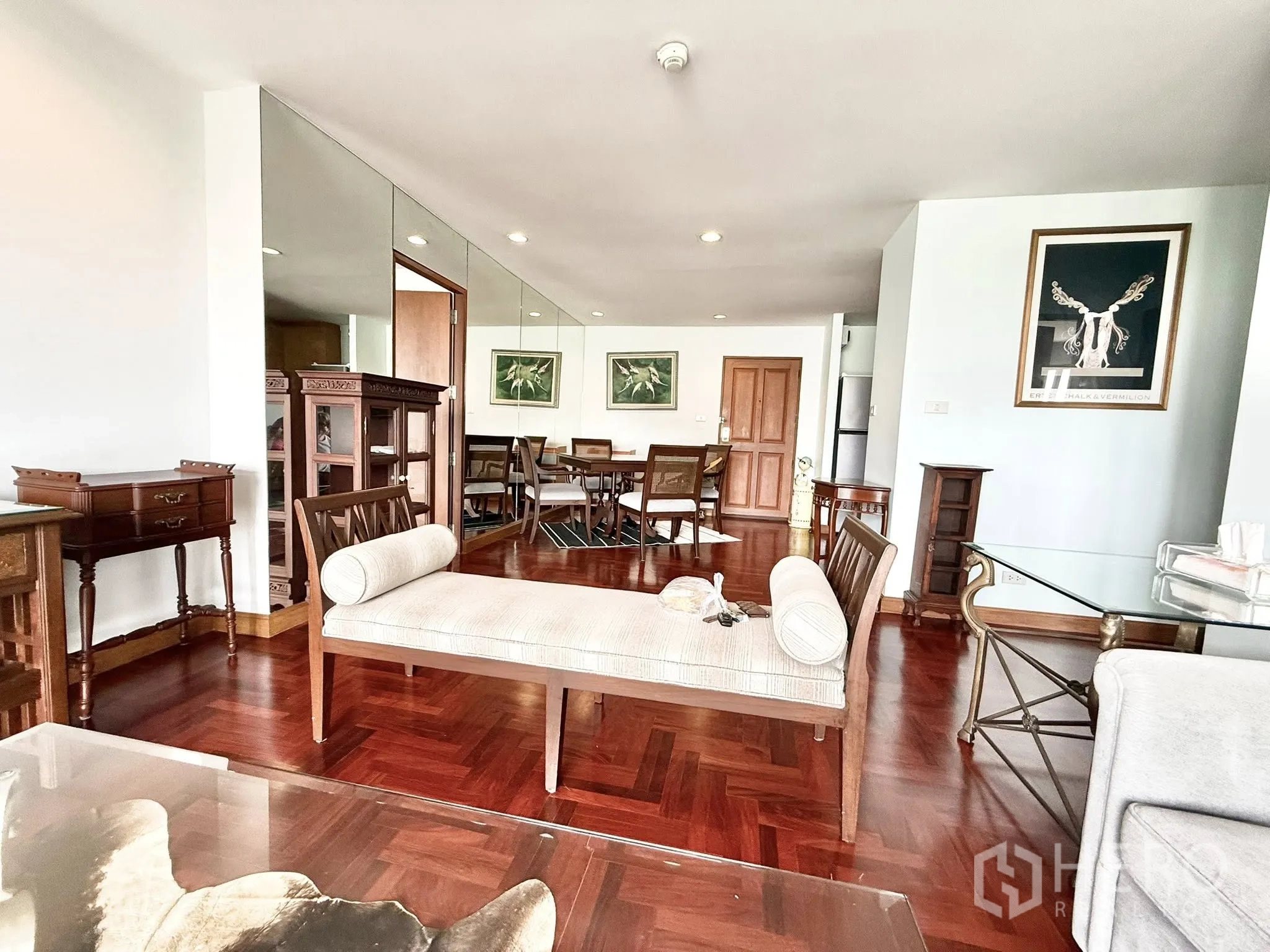 Condominium for rent in Sathon, Bangkok - Bright living and dining area with parquet floors, classic furniture and a mirror feature wall in a Sathon condo.