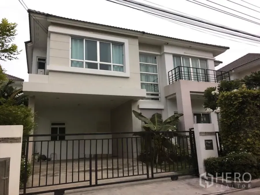 Detached House for sale in Saphan Sung, Bangkok - Modern two-storey detached house with large windows, small balcony, gated driveway and covered carport surrounded by greenery in Saphan Sung.