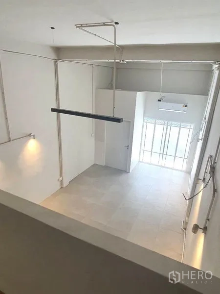 อาคารพาณิชย์ ให้เช่าในPhra Khanong, Bangkok - มุมมองจากชั้นลอยลงสู่พื้นที่หน้าร้านเพดานสูงและทางเข้ากระจกติดถนน