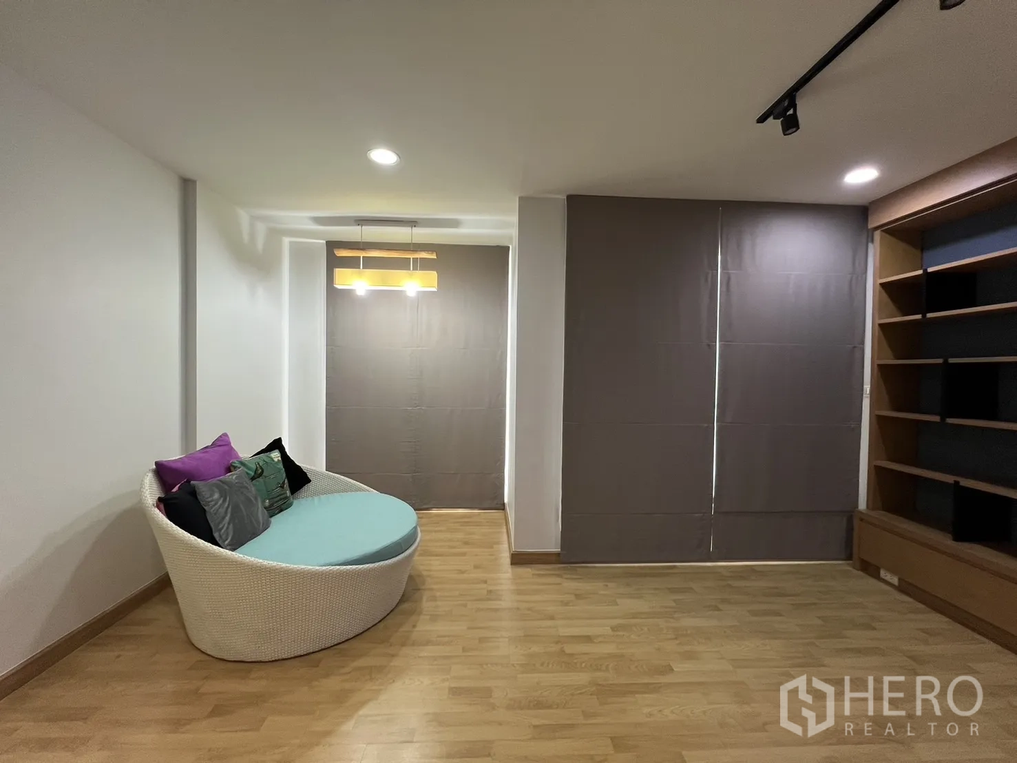 Townhouse for rent in Wang Thonglang, Bangkok - Multipurpose room with round lounge chair and built-in shelves.