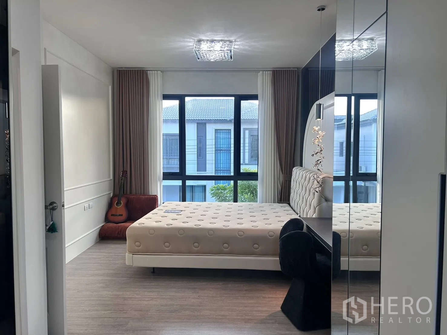 Semi-detached House for rent in Bang Phli, Samut Prakan - Spacious master bedroom with upholstered bed, large windows, and mirrored wardrobe.